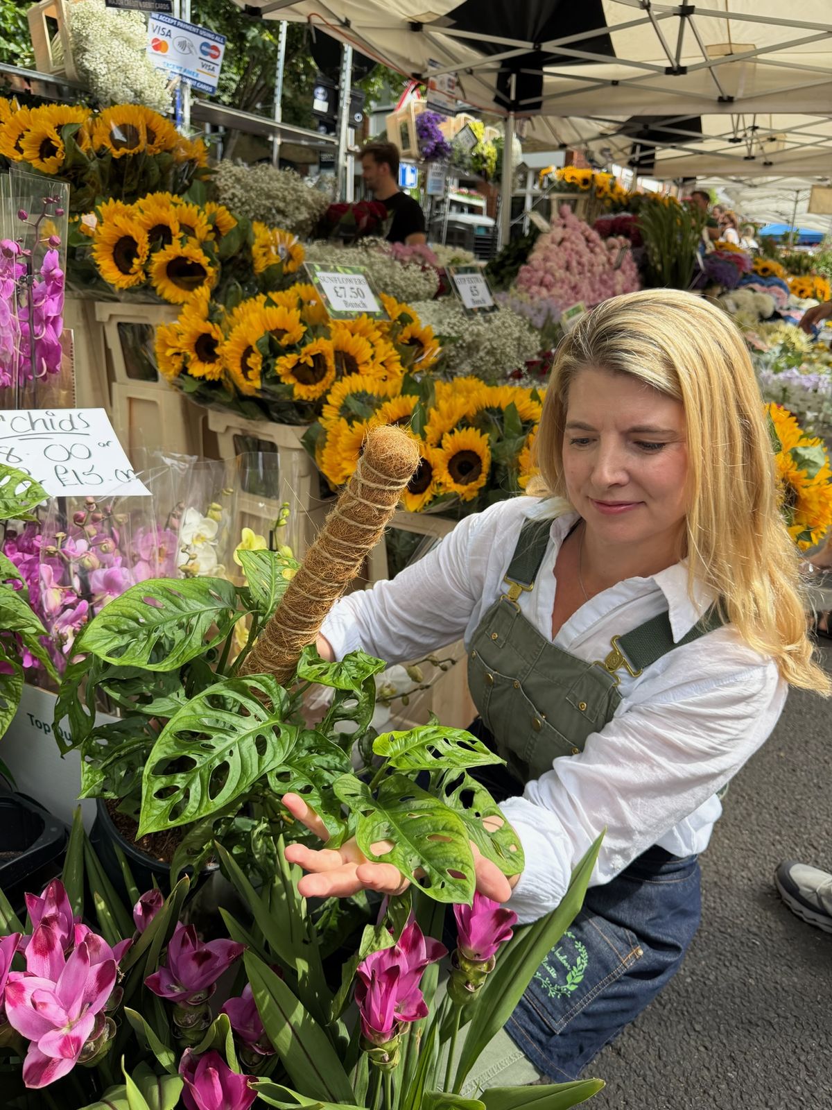 Alexa inspecting a monstera adansonii while sourcing plants at a London market