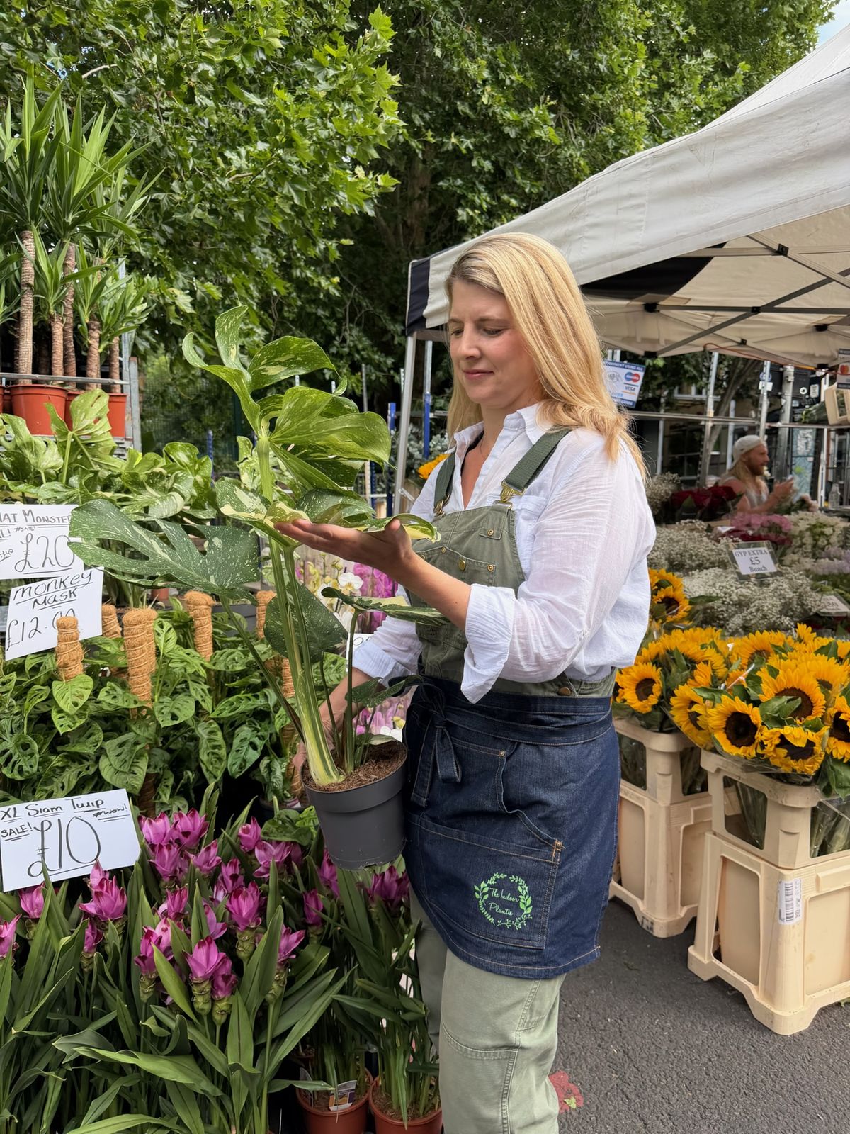 Alexa selecting a variegated monstera while plant sourcing at a London market